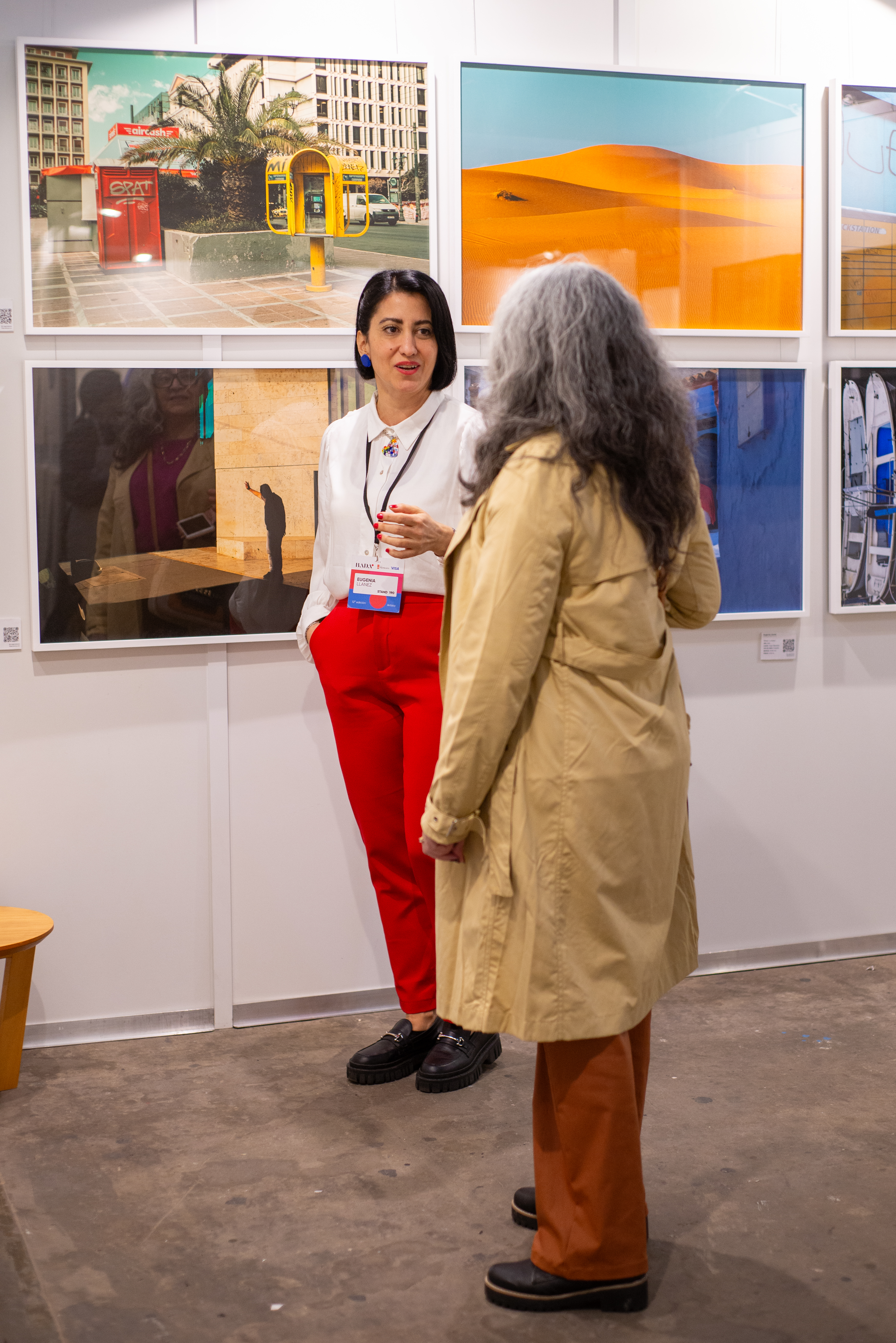 Eugenia Llanez conversando frente a obra en exposición