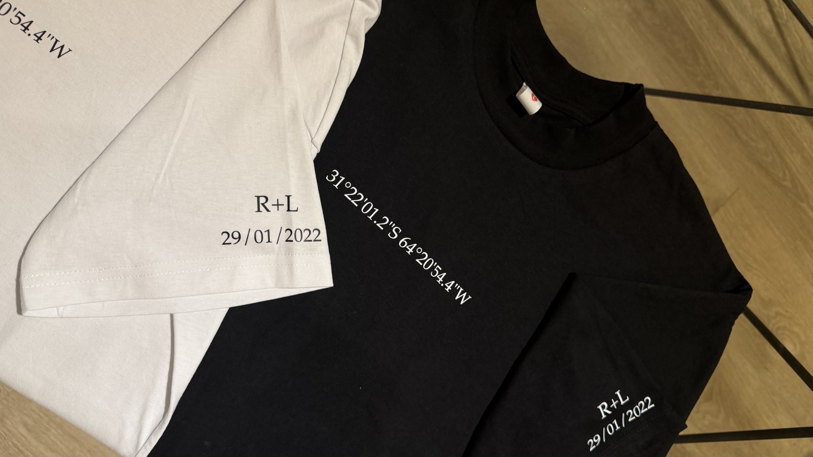 Combo de dos remeras con coordenadas, iniciales R+L y fecha 29/01/2022 estampadas
