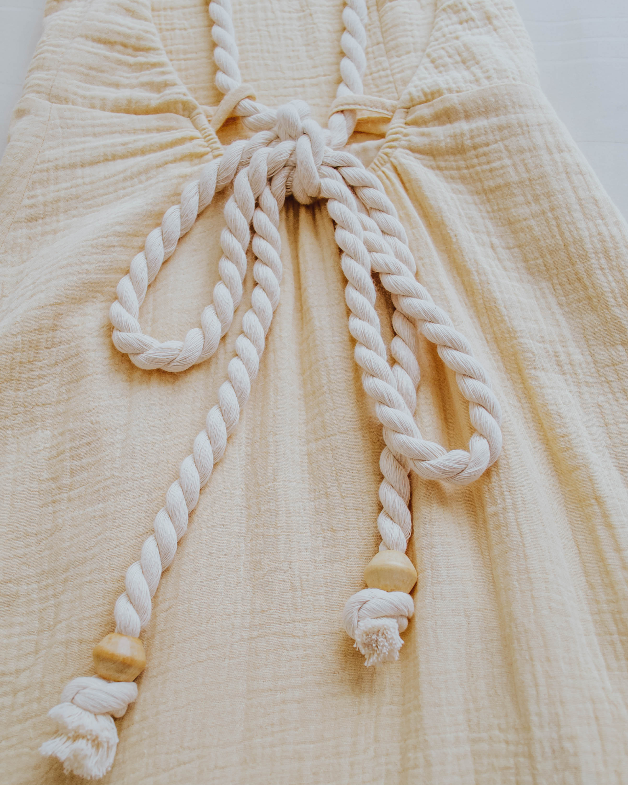 vestido de algodão amarelo com alças de cordas e ponteiras de madeira