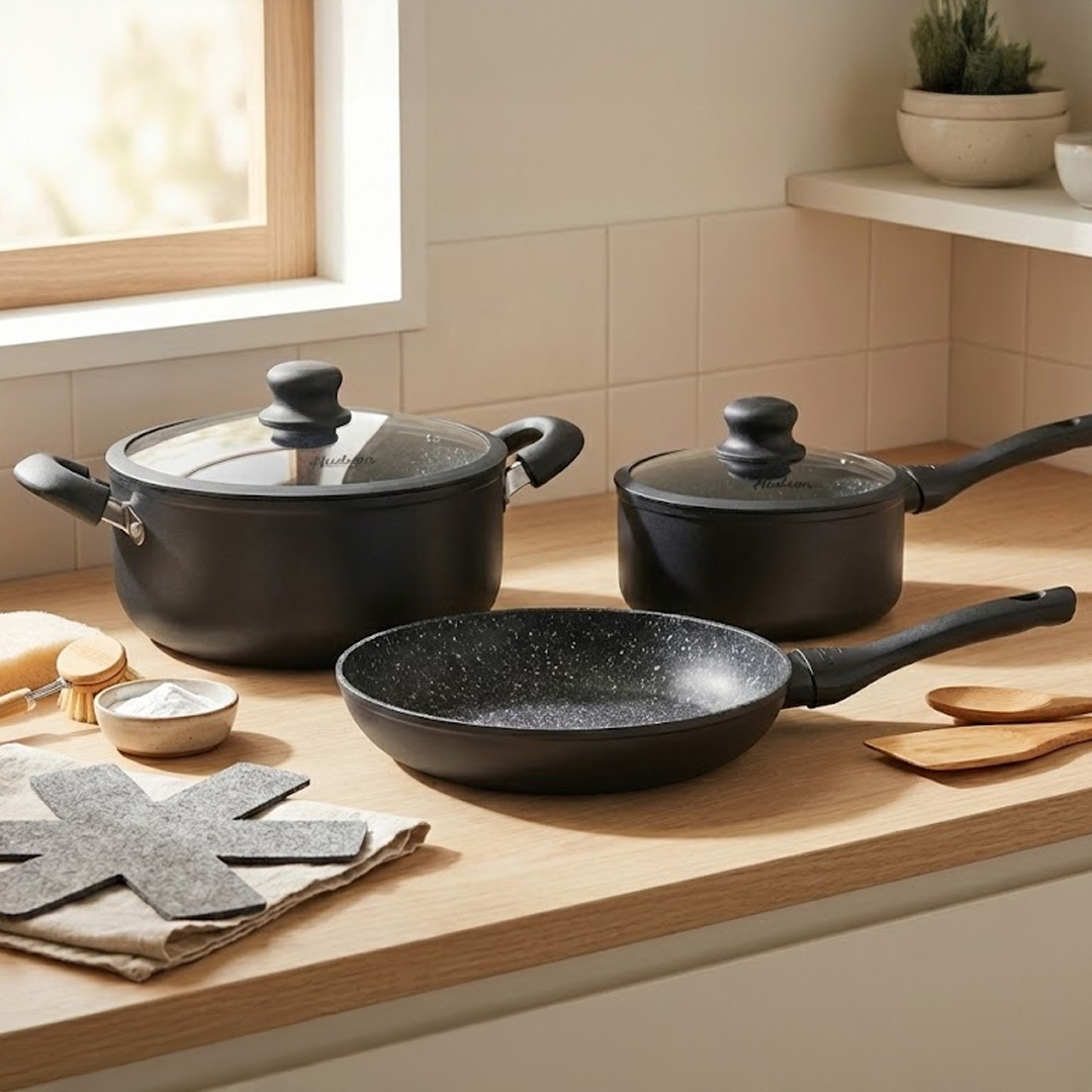 3 ollas de granito negras sobre una mesada de madera