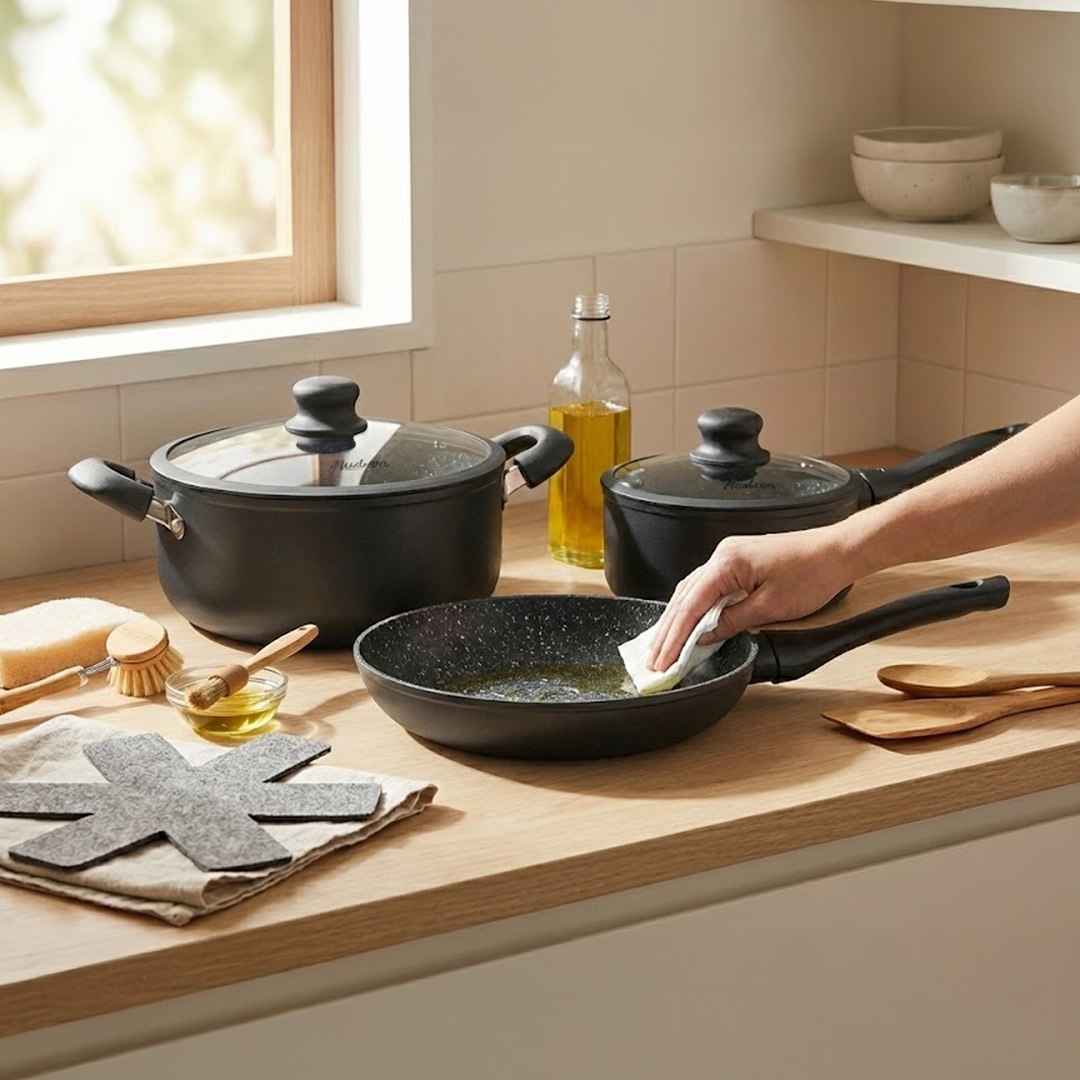 mano aplicando aceite en una olla de granito para curarla y demas