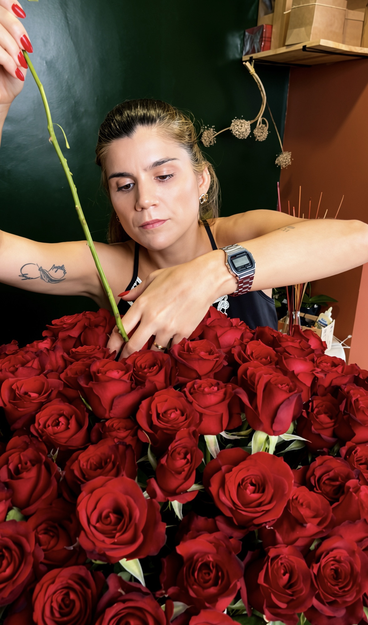 Bruna Barros montando um arranjo de rosas vermelhas na Flora de Verdade