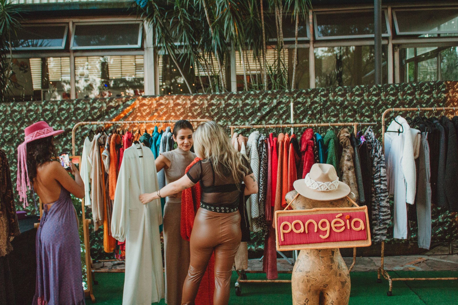 “Clientes conhecendo as criações autorais da Pangéia em um espaço de moda, arte e expressão.”