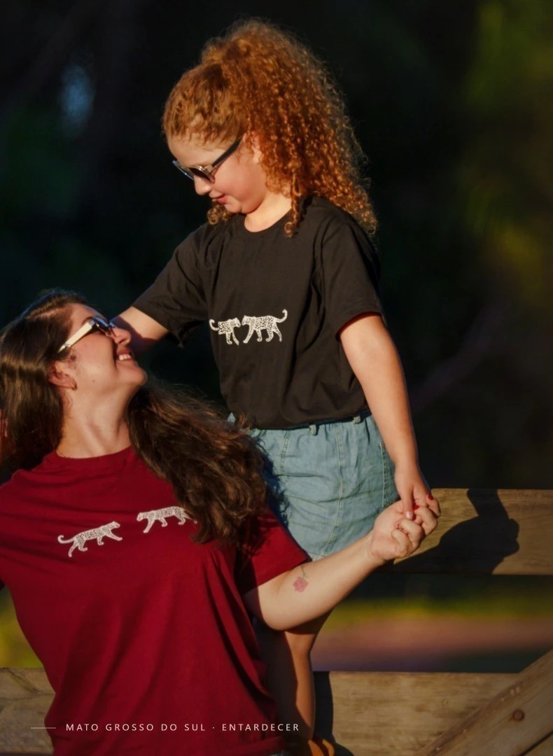 Mãe e filha vestindo camisetas evertees com a estampa Onça, ao entardecer em Mato Grosso do Sul