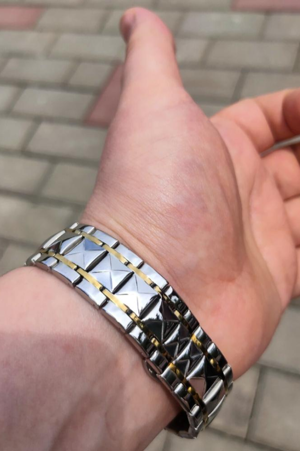 A hand with a silver and gold bracelet

AI-generated content may be incorrect.