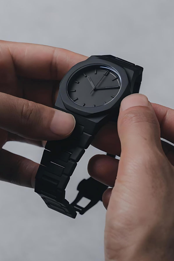 A person holding a black watch

AI-generated content may be incorrect.