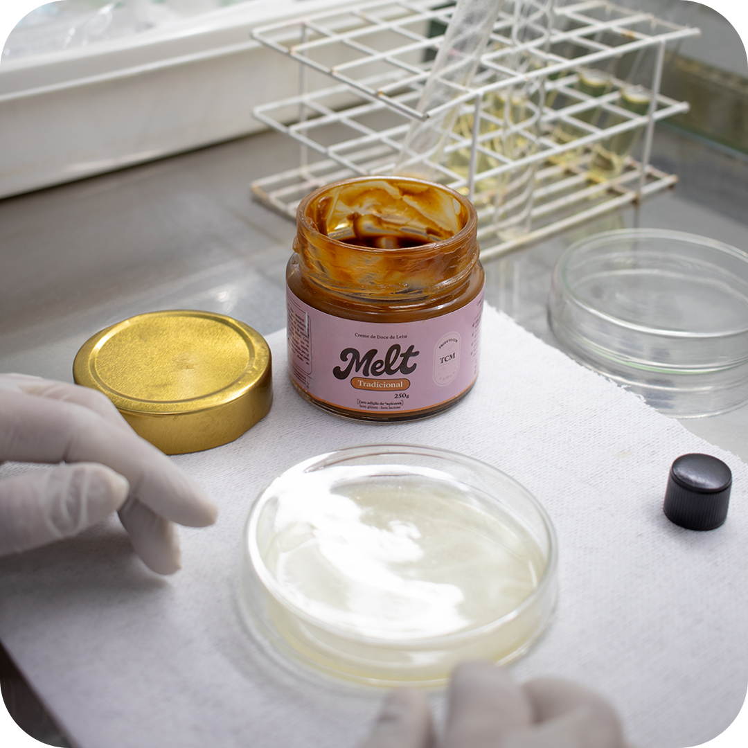 Mão segurando pote de doce de leite Melt