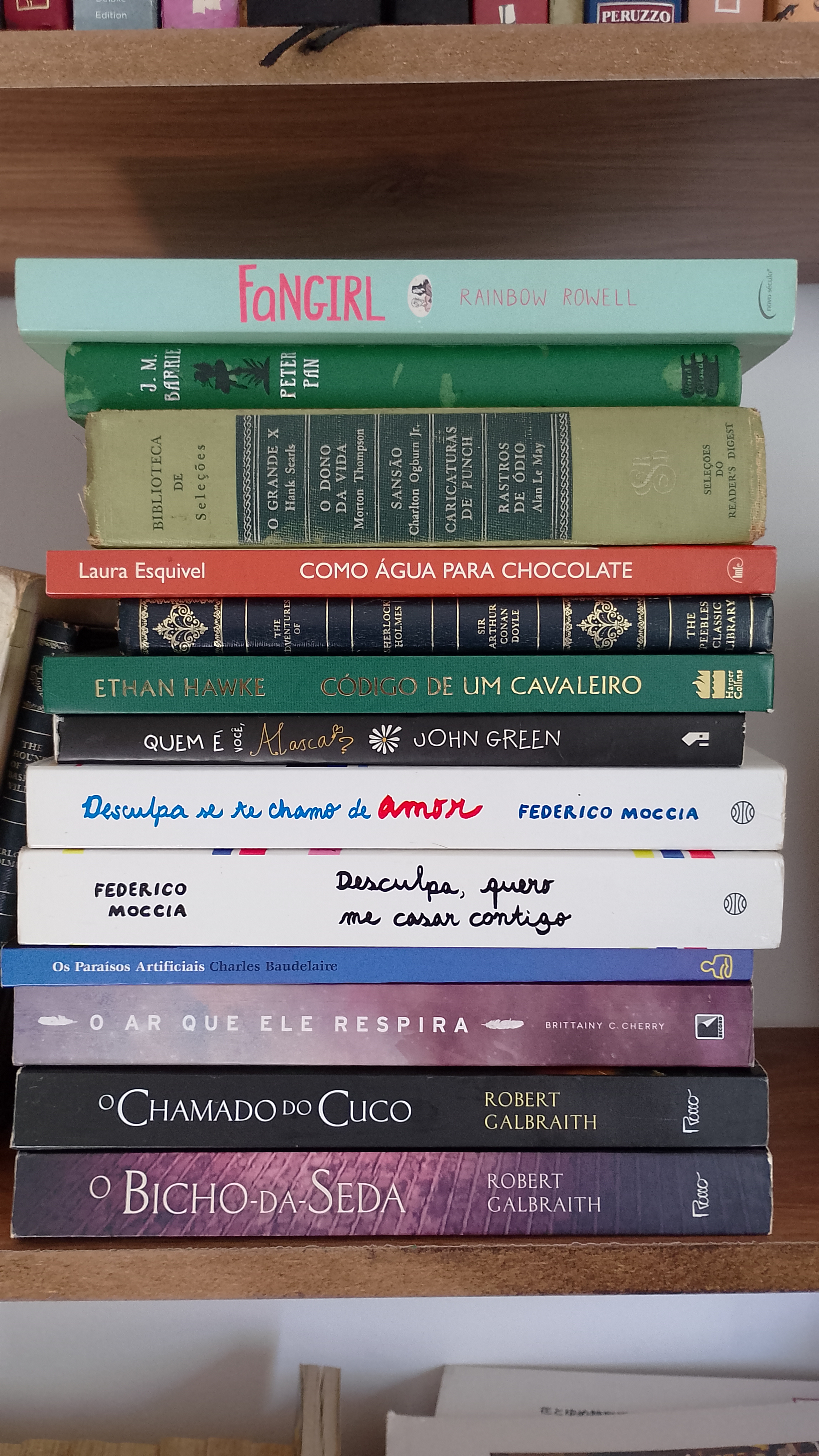 Livros usados organizados em pilhas com as lombadas visíveis para avaliação de compra pela Entretantos Livros.
