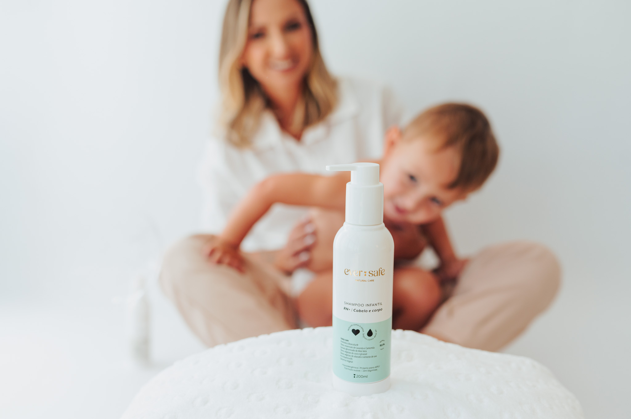 Bethania com seu filho ao fundo e shampoo infantil Ever Safe em destaque