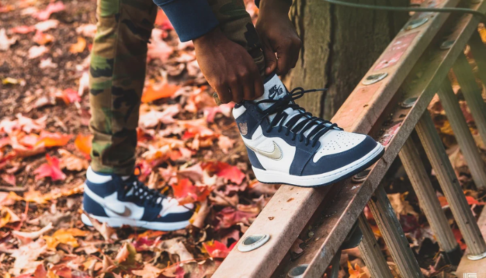 Air Jordan 1 High CO.JP Midnight Navy com detalhes prateados e cabedal azul-marinho.