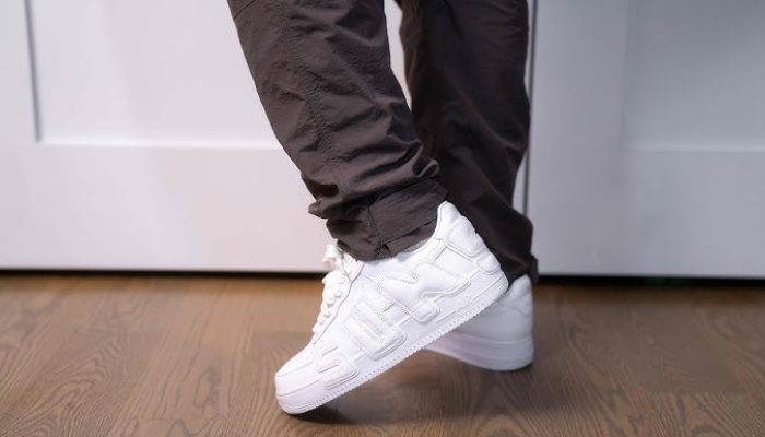 Cactus Plant Flea Market x Nike Air Force 1 Low White com detalhes reflexivos e inscrição “Sunshine”.