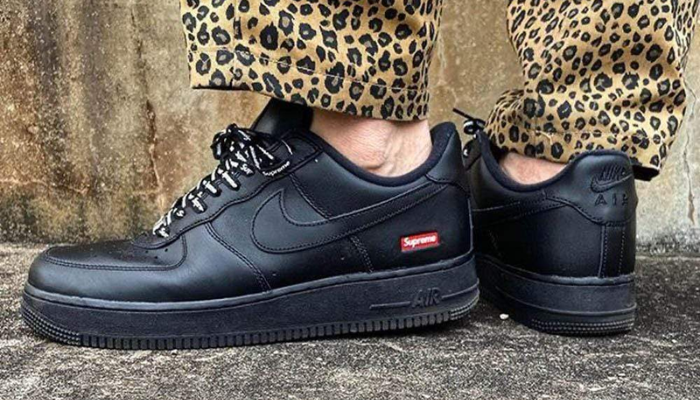 Tênis Supreme x Nike Air Force 1 Low Black em couro preto com logo Supreme vermelho no calcanhar.
