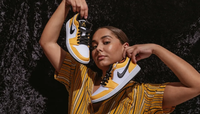 Air Jordan 1 Low Laser Orange feminino com detalhes em couro laranja, branco e preto.