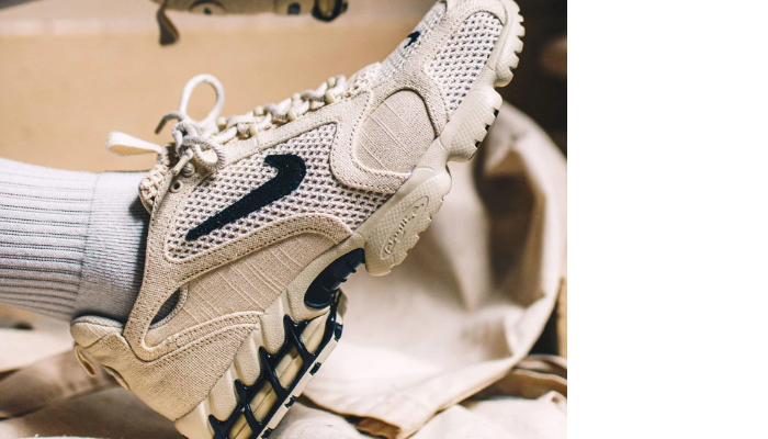 Tênis Stussy x Nike Air Zoom Spiridon Caged Fossil bege com detalhes pretos e tecnologia Zoom Air no calcanhar.