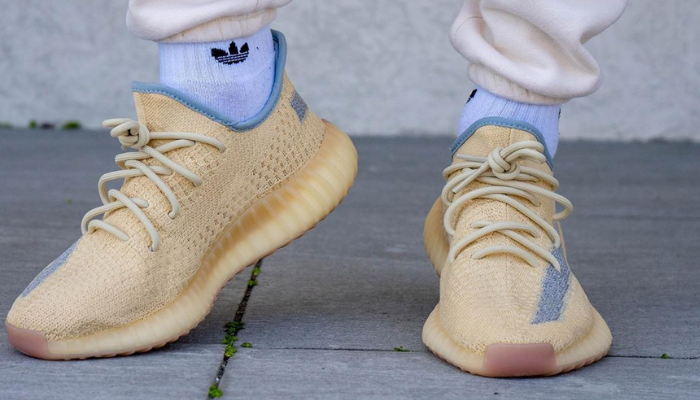 Tênis Yeezy Boost 350 V2 Linen bege com faixa lateral cinza e interior azul acinzentado.