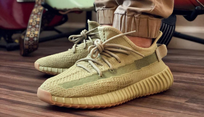 Tênis Yeezy Boost 350 V2 Sulfur amarelado com faixa verde oliva e sola de borracha de goma.