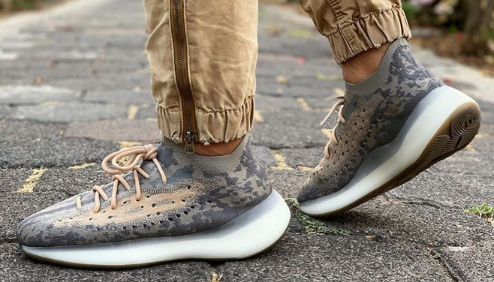 Tênis Yeezy Boost 380 Mist em Primeknit marrom e bege com entressola Boost translúcida.