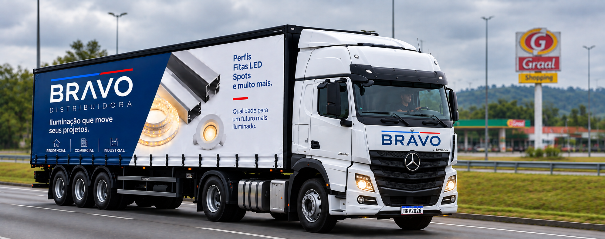 Caminhão personalizado da Bravo Distribuidora transportando perfis, fitas de LED e spots em rodovia.