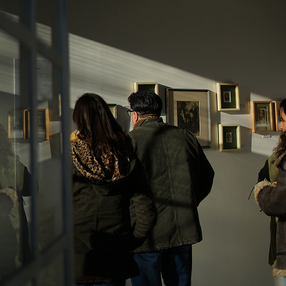 Visitantes mirando obras colgadas en el taller