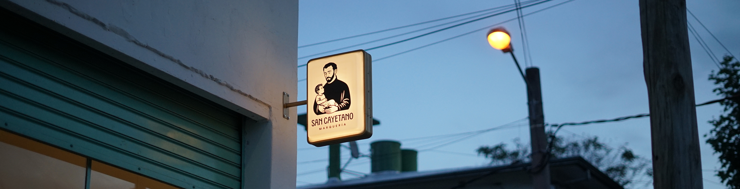 Fachada del taller San Cayetano Marquería con el cartel iluminado