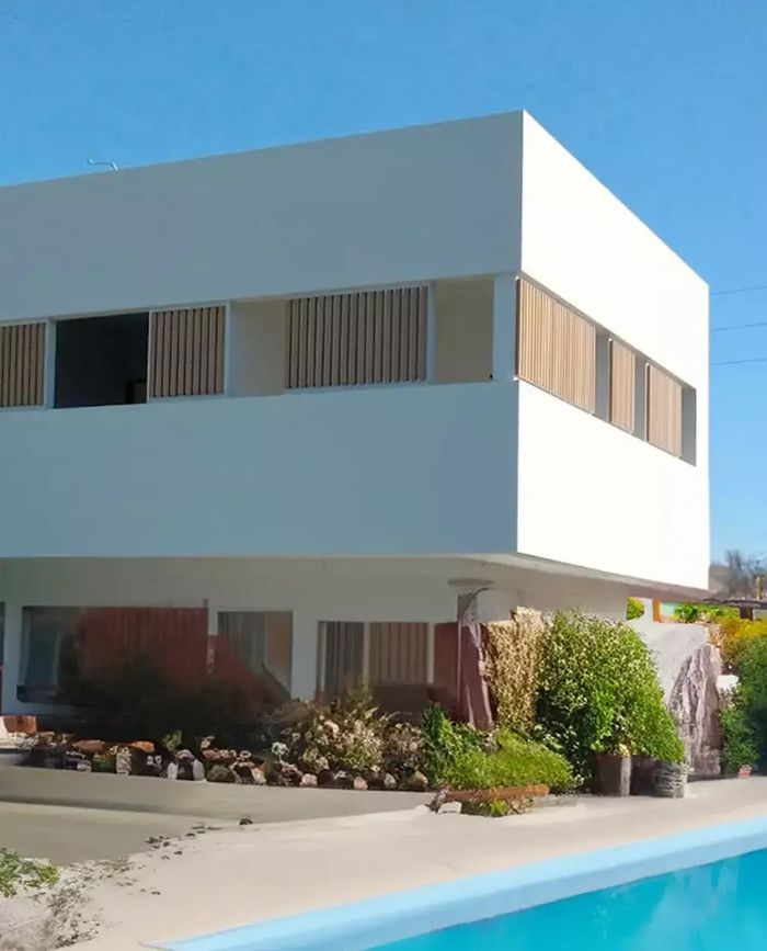Fachada de una casa con celosías de columnas WPC Vankka color Fresno en las ventanas de la planta alta