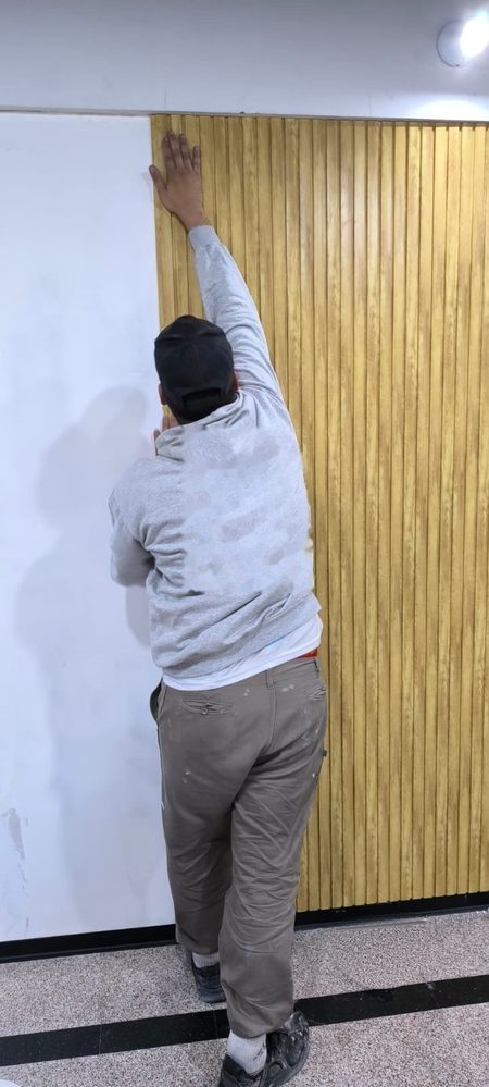 Instalador colocando wall panel PS color Pino en vertical sobre una pared interior