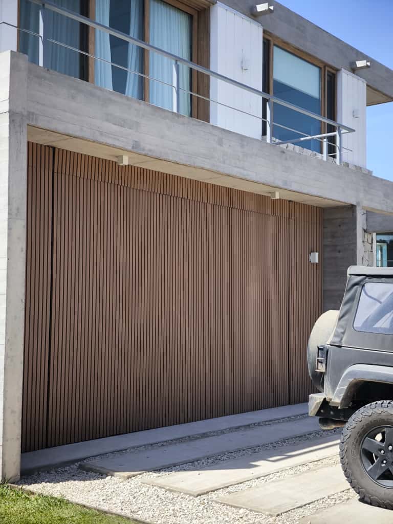 Fachada de una casa con la pared exterior revestida en wall panel WPC Vankka color Fresno colocado en vertical