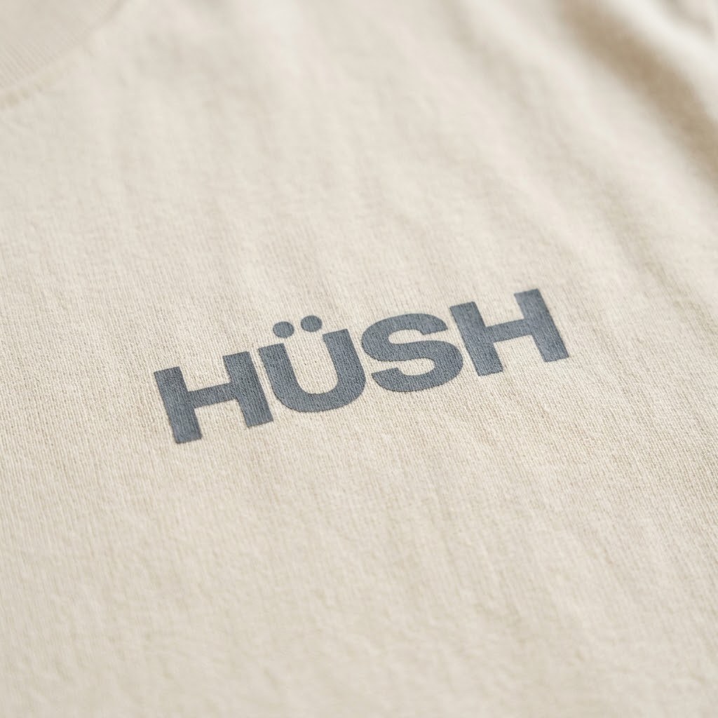 Detalle del wordmark Hüsh al pecho