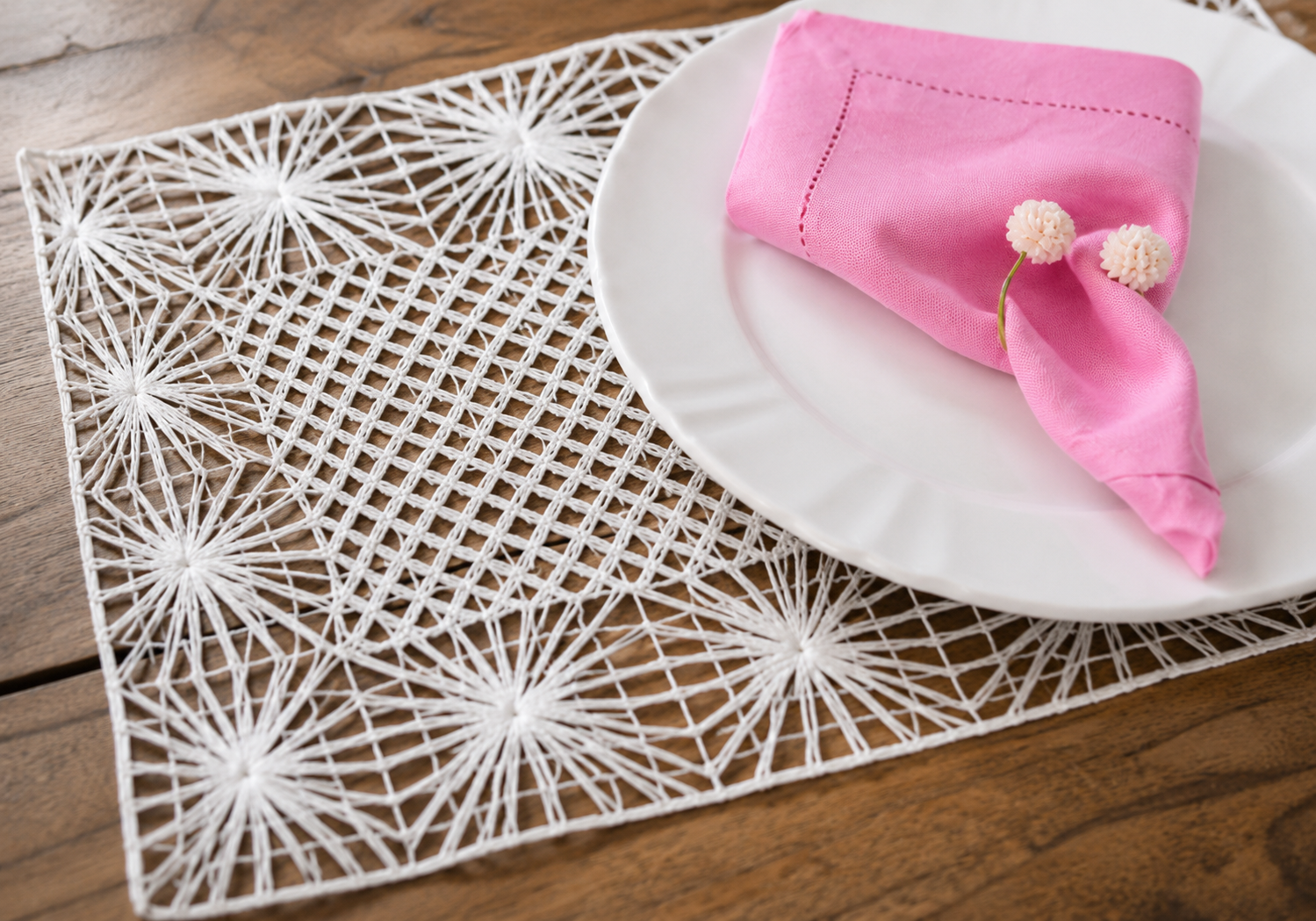 Detalhe do jogo americano artesanal em renda fil&eacute; branca com guardanapo rosa