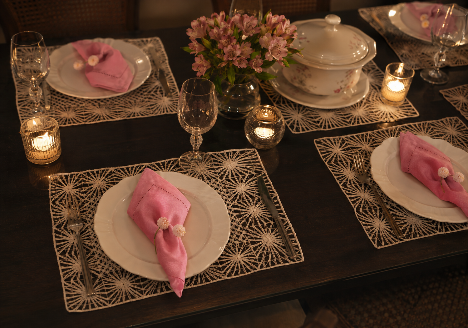 Mesa de jantar &agrave; noite com jogos americanos de renda fil&eacute; e guardanapos rosa