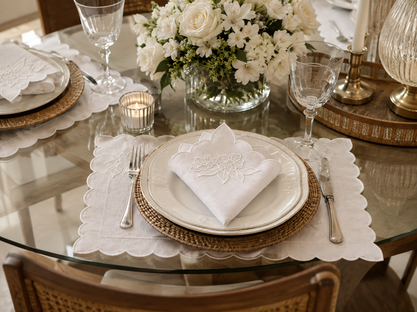 Sugest&atilde;o de mesa posta com jogo americano branco bordado, guardanapo, pratos, ta&ccedil;as, flores e sousplat