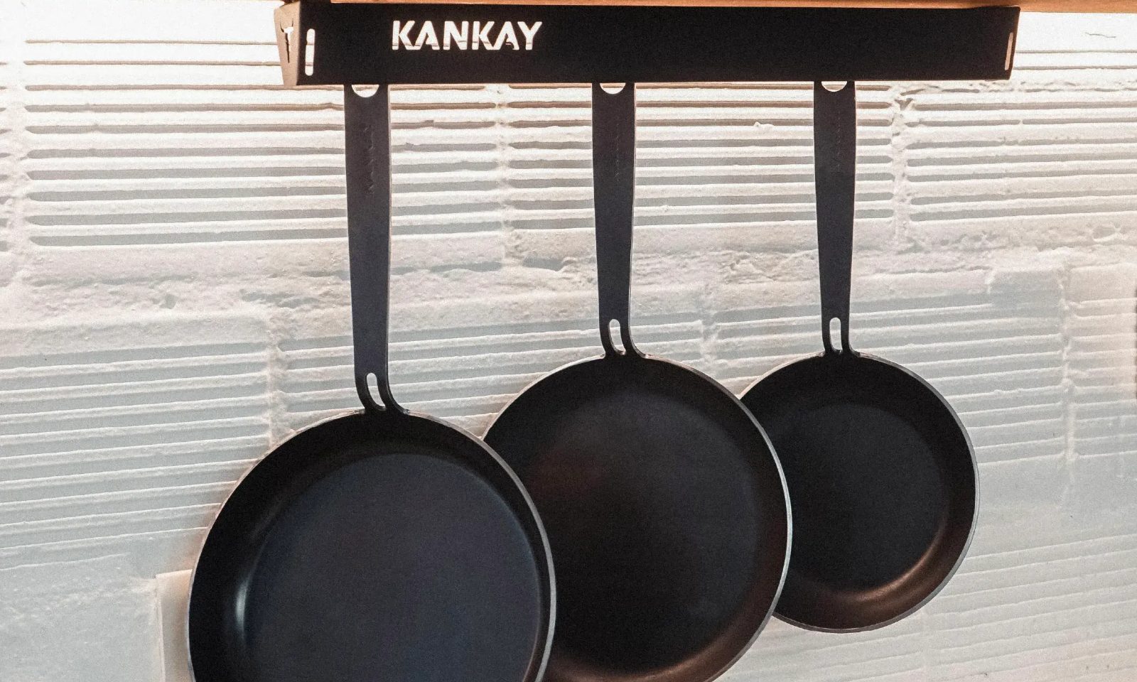 Frigideiras Kankay de aço carbono penduradas na cozinha