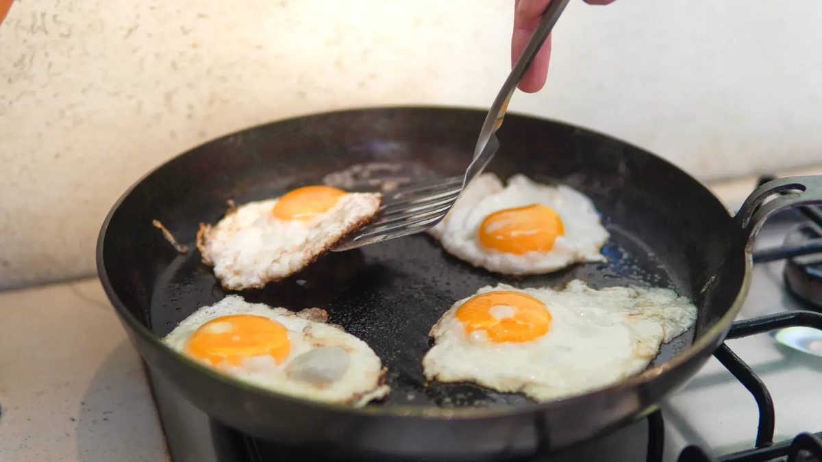 Ovos fritos soltando da frigideira de aço carbono
