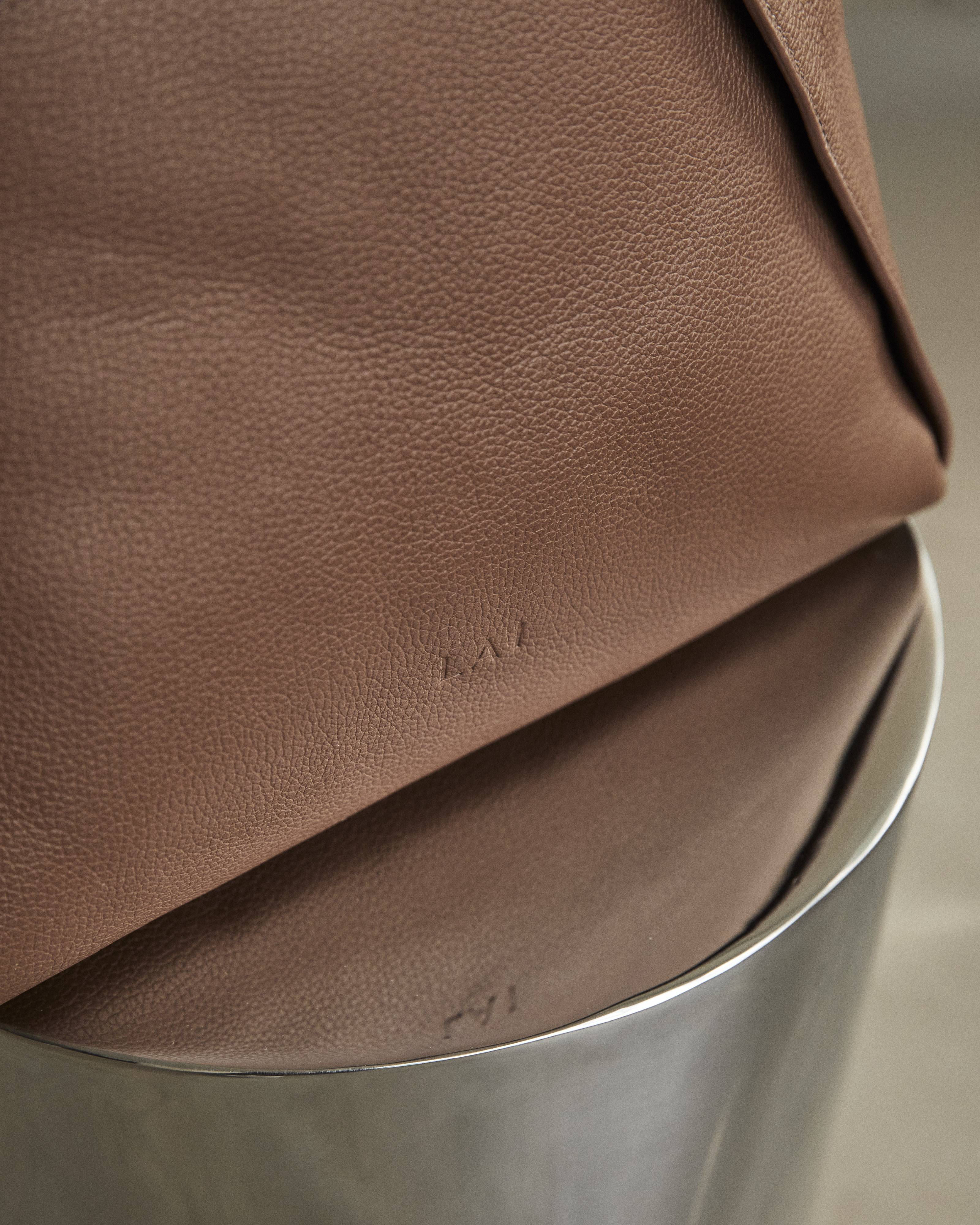 Bolsa Lai Bag em couro taupe com a marca em baixo-relevo