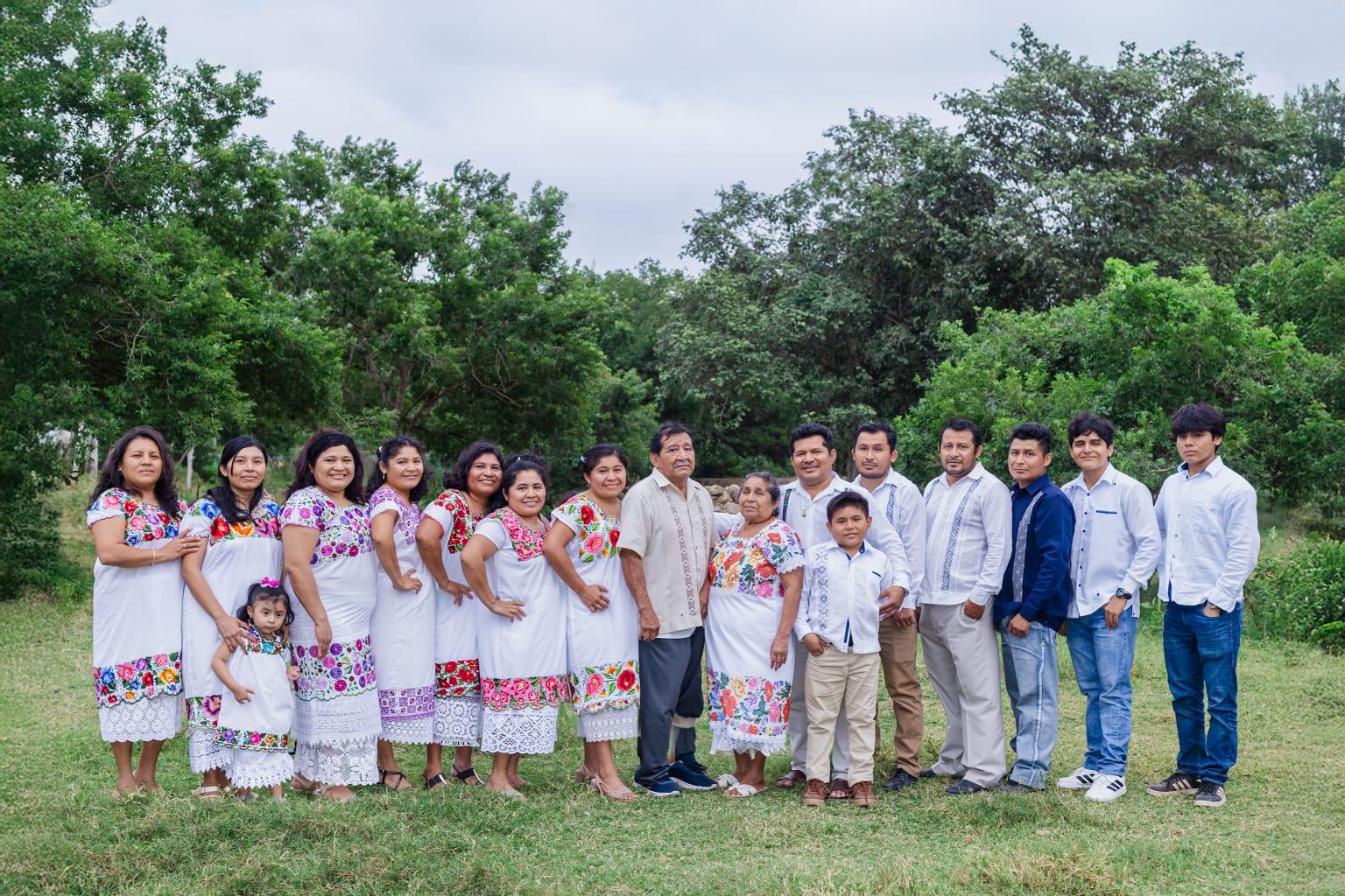 Familia y artesanos del taller Típicas Pat Carrillo de Kimbilá, 4 generaciones portando hipiles y guayaberas bordadas en máquina 20U