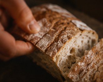 Rebanada de pan de masa madre de Corteza en la mano