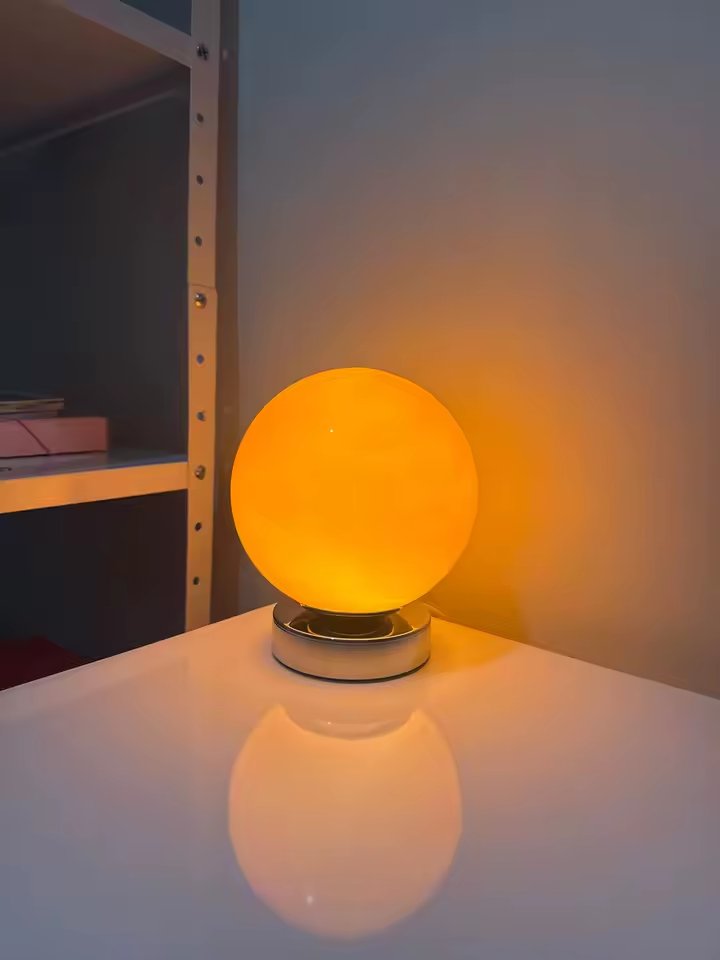 Luminária laranja acesa na prateleira