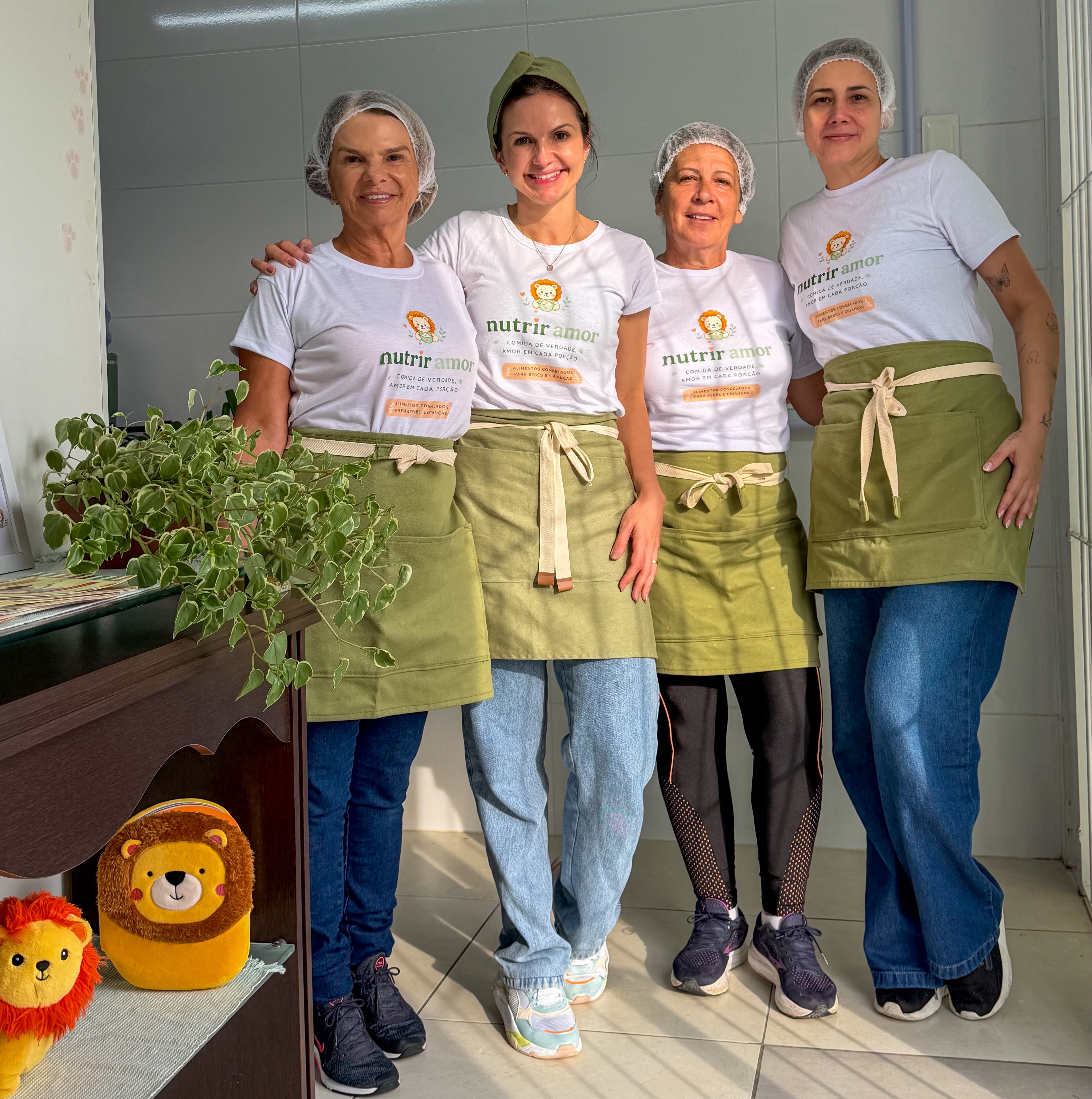 Equipe da Nutrir Amor na cozinha, com camisetas da marca