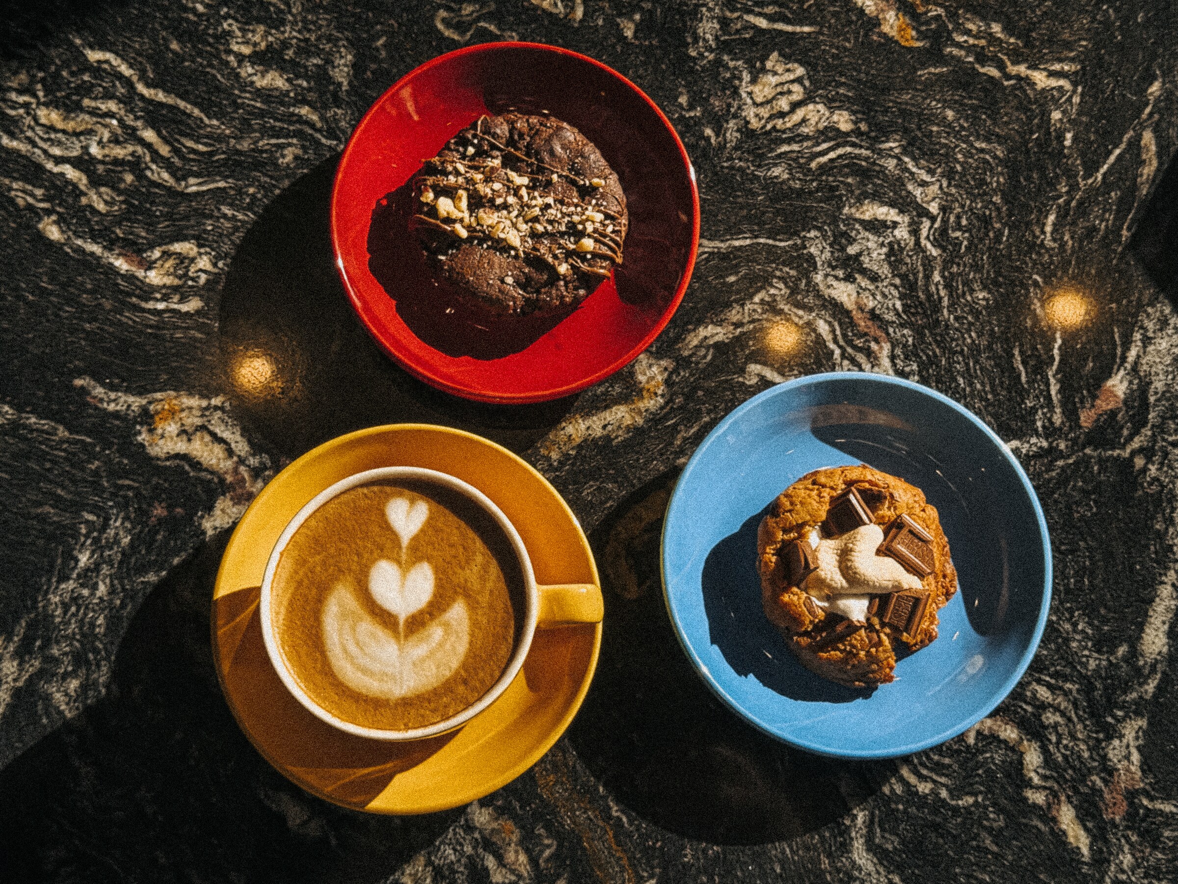 Café con arte latte y pastelería de Kaffein sobre mármol