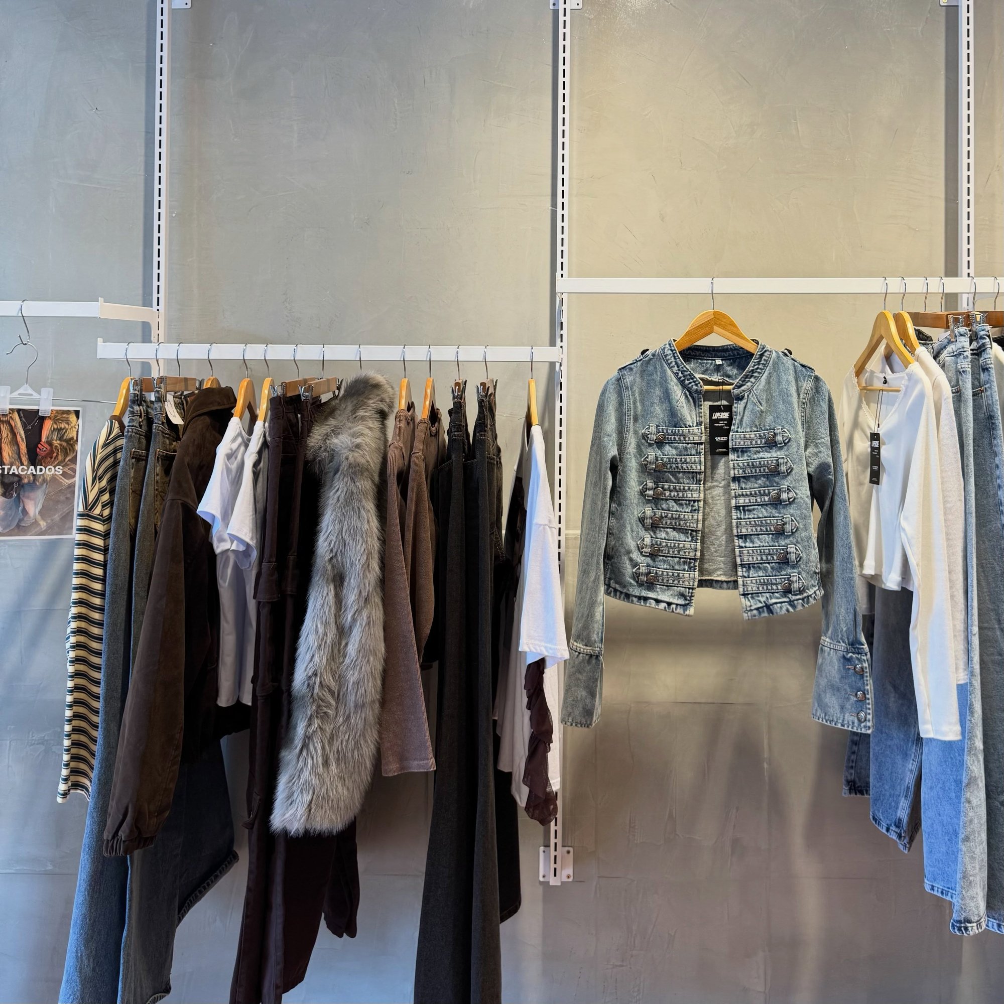 Perchero con camperas de jean y pantalones, y una chaqueta militar de jean colgada aparte