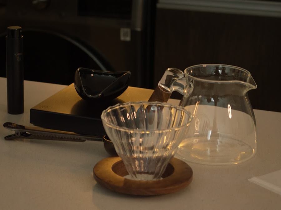 Molinillo, balanza, dripper de vidrio y jarra preparados para una degustación