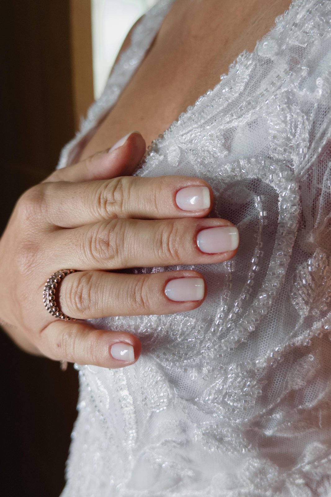 Detalhe da mão da noiva sobre o vestido, cobertura por Bianca