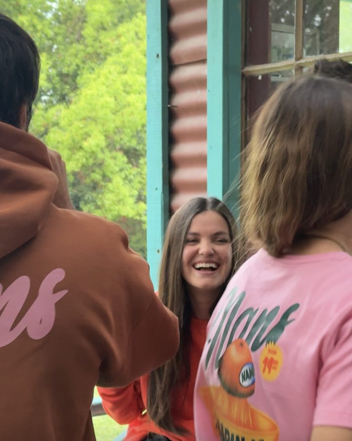 Amigos riéndose con buzo y remera Nans La Naranja después del partido
