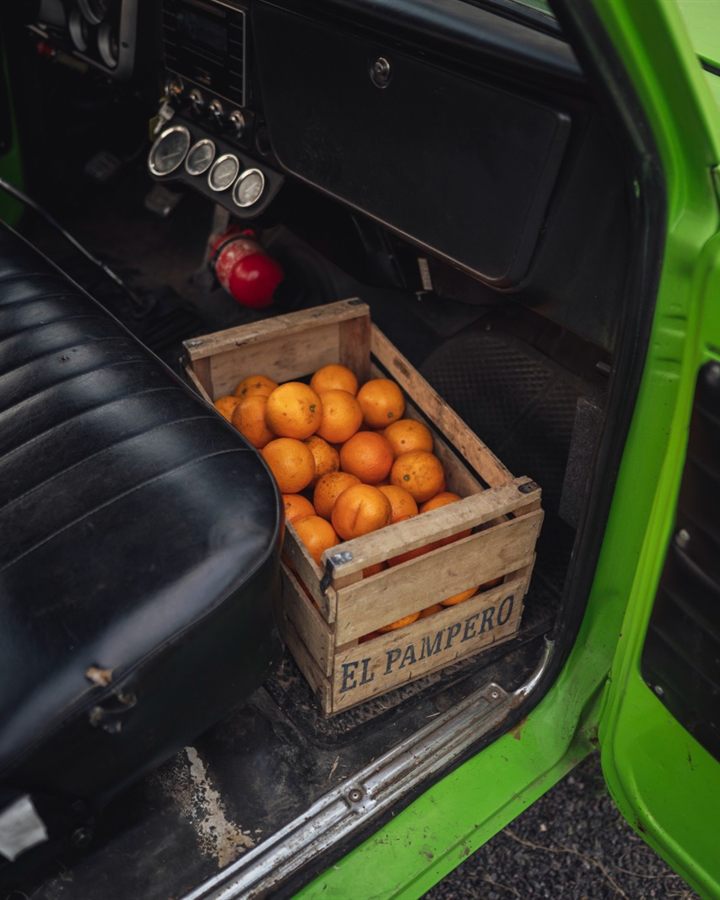 Cajón de naranjas en una camioneta verde, viaje entre torneos
