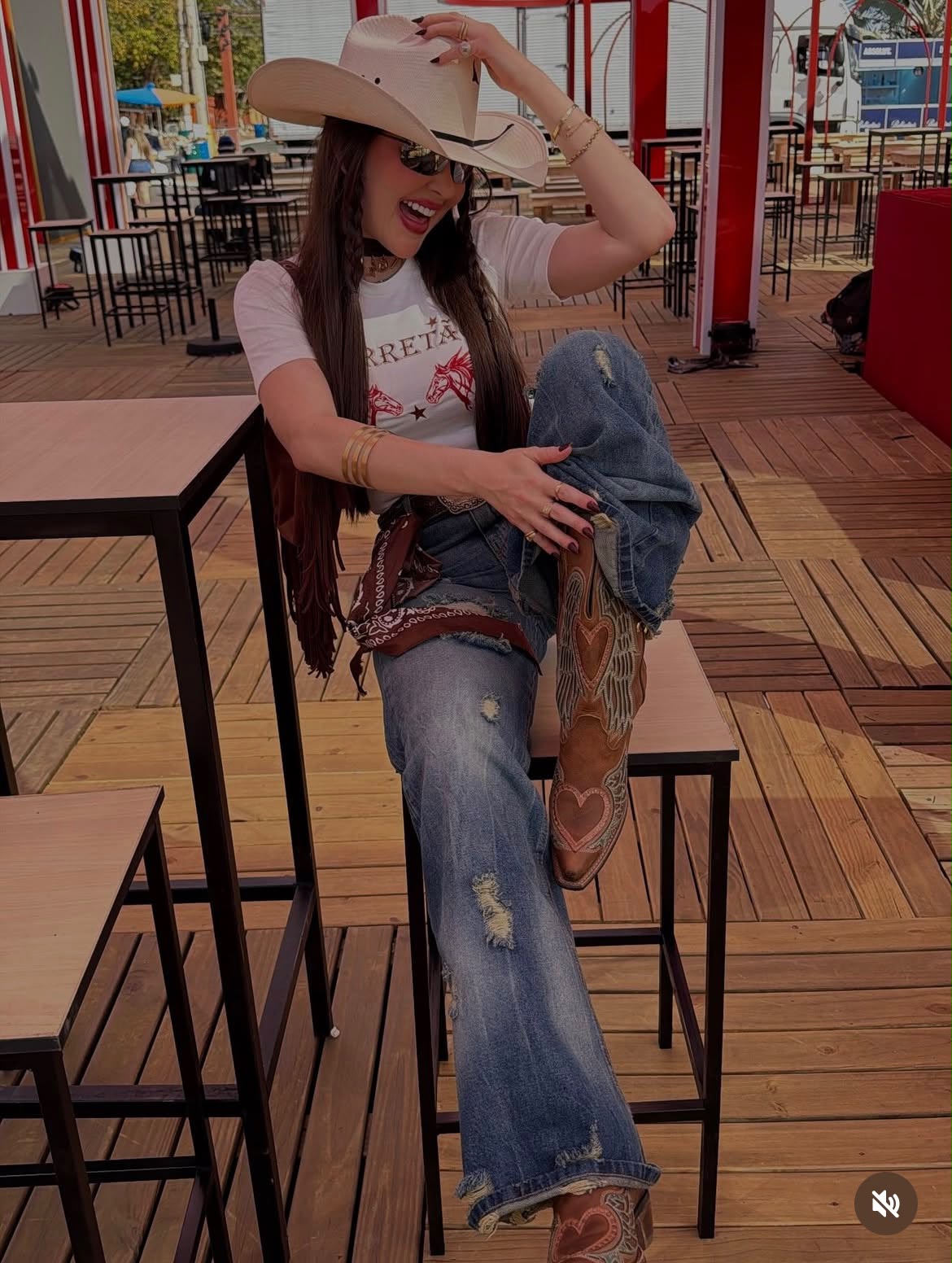 Mari Perillo de chapéu, camiseta branca, jeans destroyed e bota com coração