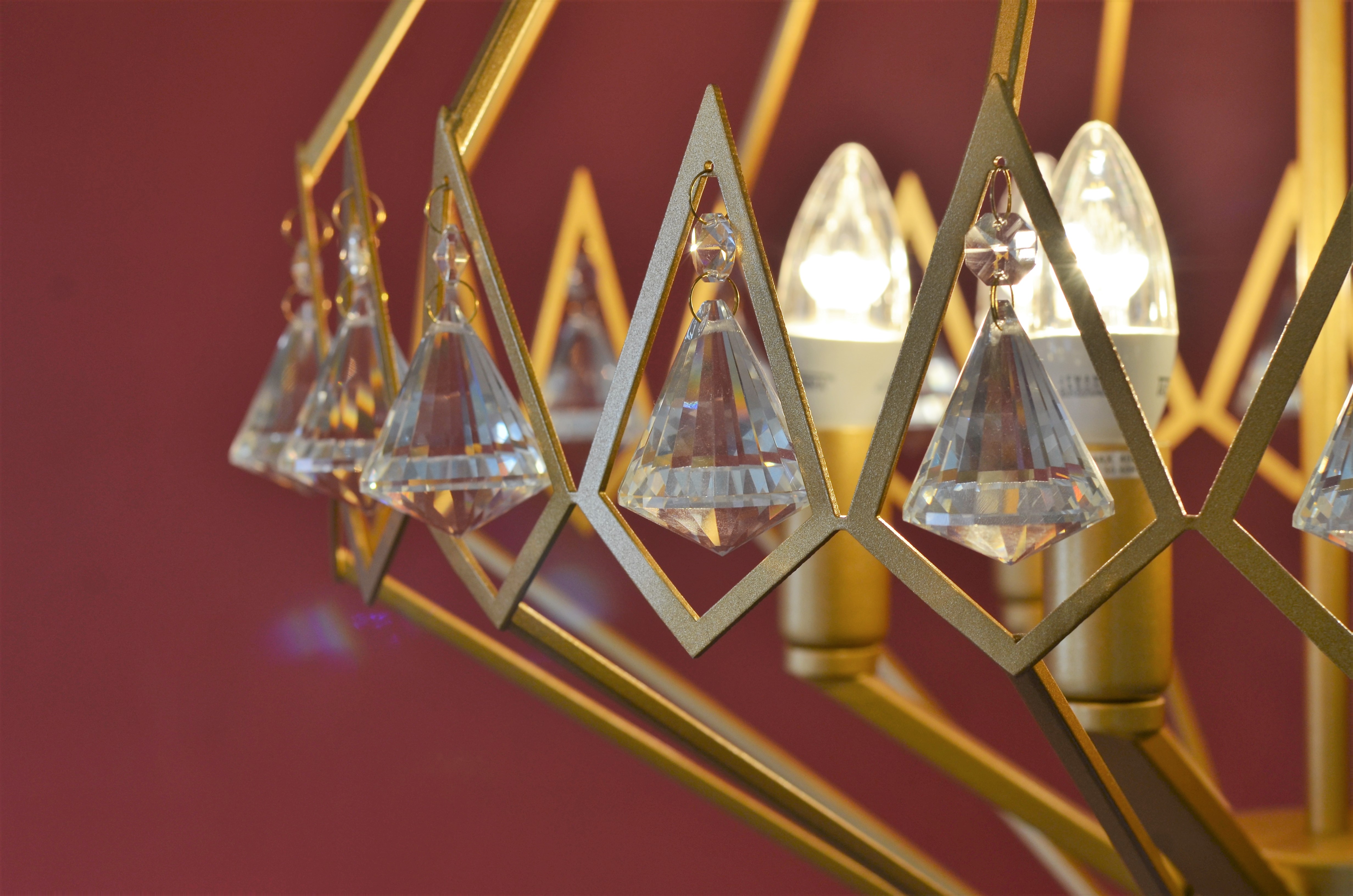 Lustre pendente moderno em cristal dourado com design em pião, ideal para sala de jantar, estar e área gourmet. Lustres Gênesis loja online de Lustres e Iluminação Decorativa