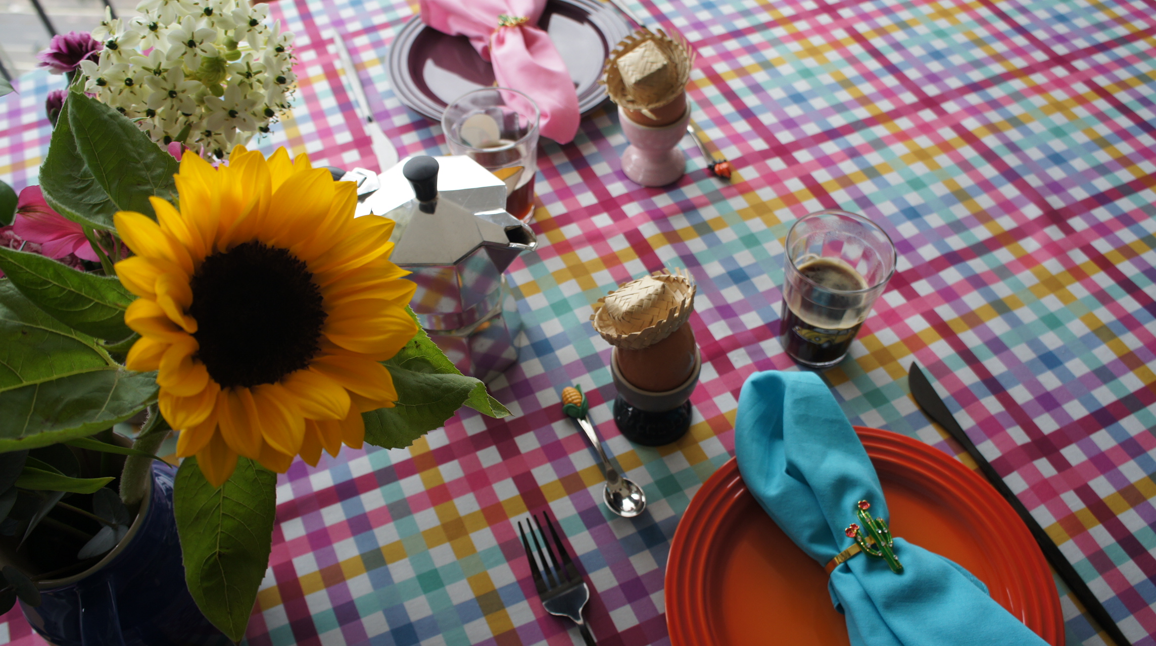 Mesa de Festa Junina colorida com guardanapo rosa, flores e caf&eacute;