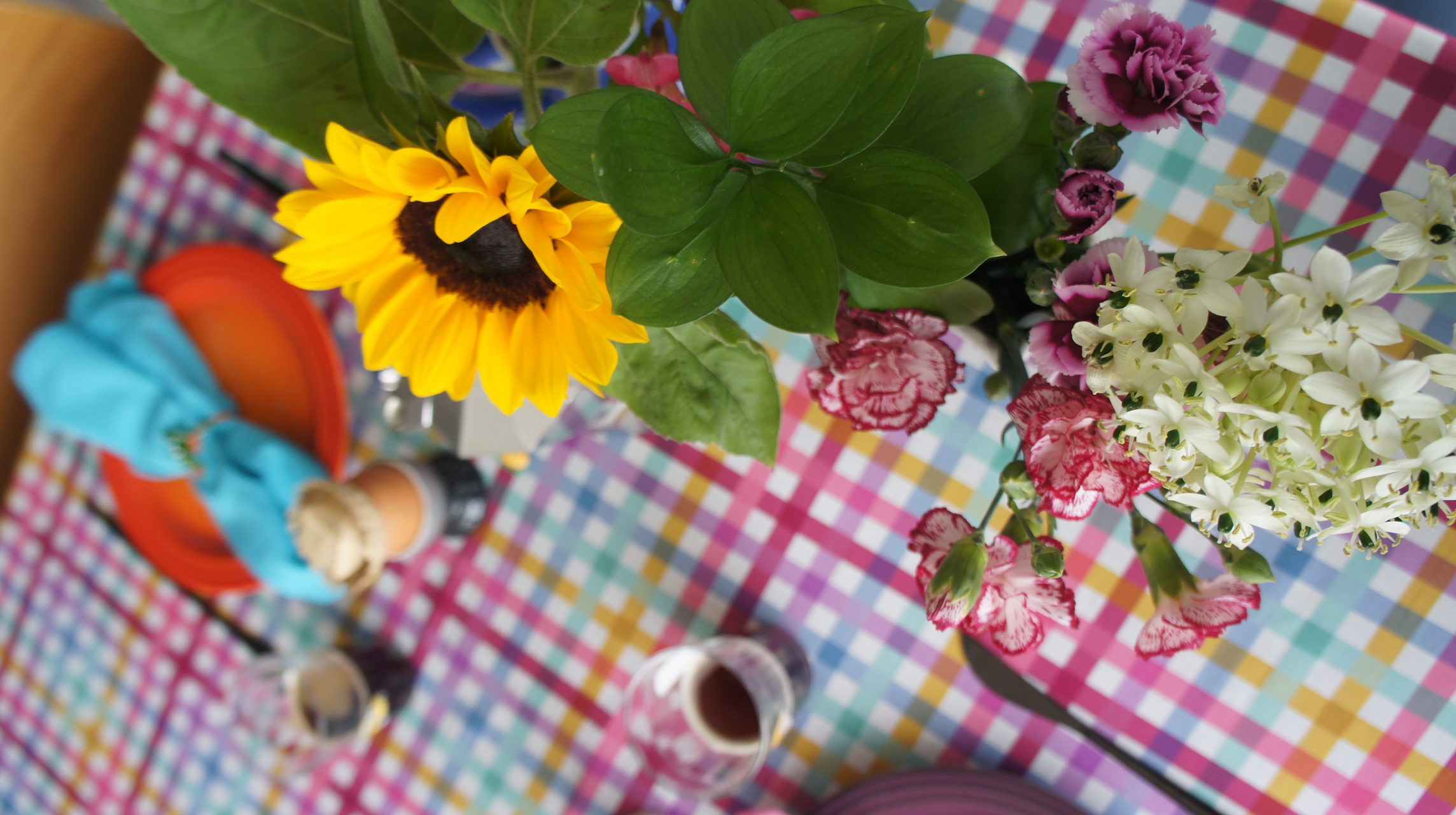 Flores coloridas sobre mesa xadrez para Festa Junina