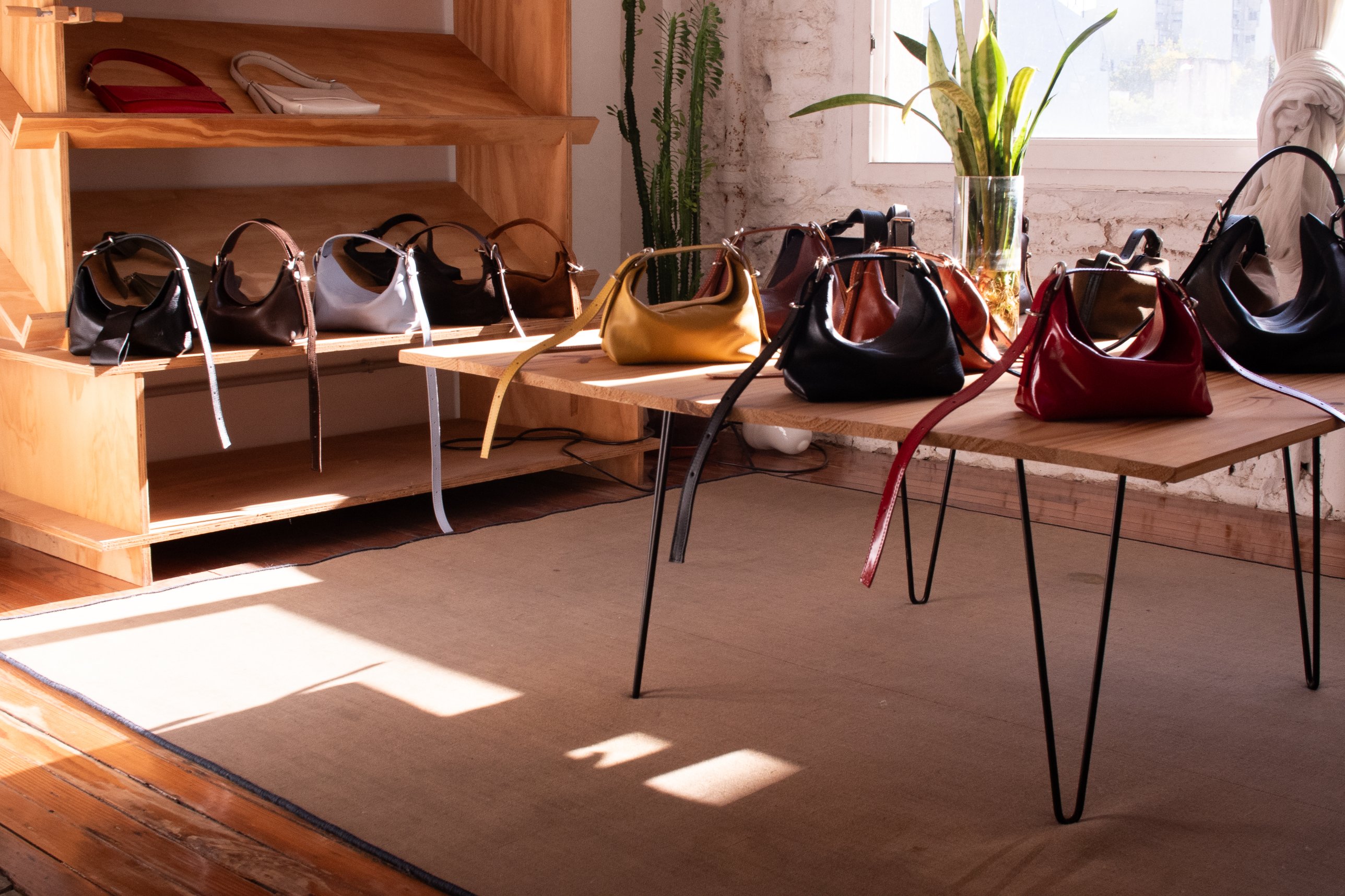 Carteras Bastardo sobre la mesa y los estantes del taller, con luz de la ventana