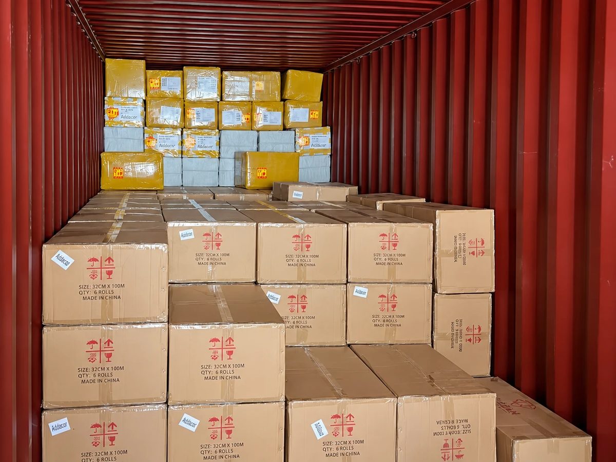 Interior de un contenedor cargado con cajas de insumos con la etiqueta Addacor